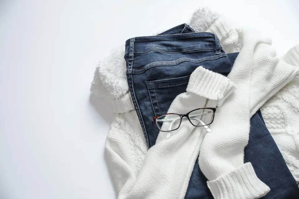 Folded jeans and a white knit sweater